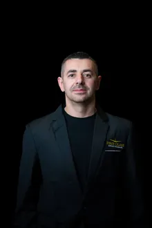 First Class Airport Transport chauffeur in the company black blazer with the gold embroidered logo
